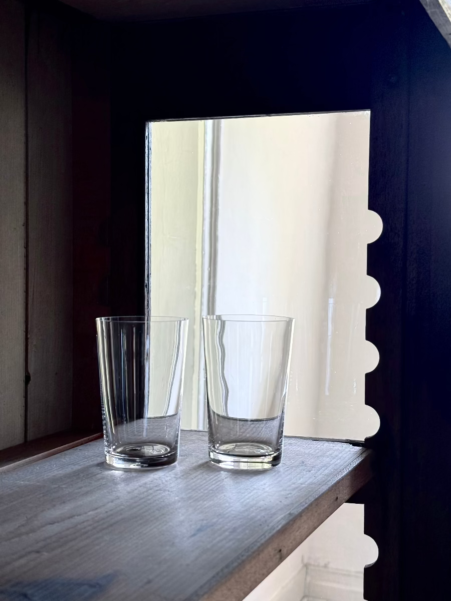 Deborah Ehrlich Simple Crystal Red Wine Glasses in a dark wooden vitrine in front of a deep bright window
