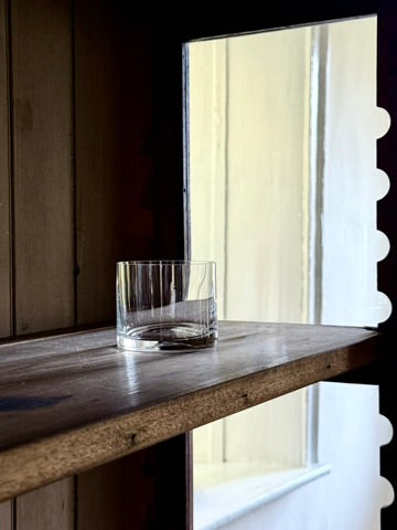 Deborah Ehrlich Simple Crystal Rocks Glass in a dark wood vitrine in front of a bright deep windowsill